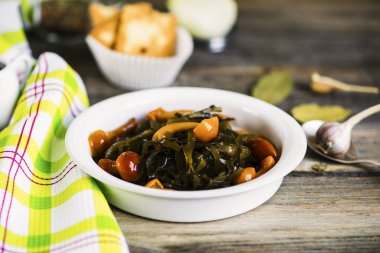 deniz yosunu ve ahşap bir gemide bir tabak içinde salamura mantar salatası