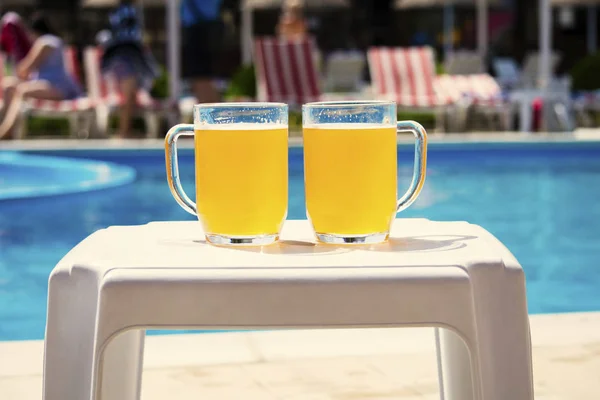 夏天在游泳池附近的水杯啤酒度假 — 图库照片