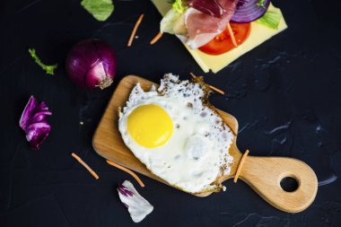 Sahanda yumurta ve jambon peynir, sebze siyah bir zemin üzerine