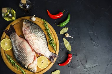 siyah arka plan üzerine ahşap tahta üzerinde baharatlar ile taze çiğ balık