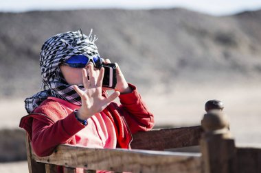 Sevimli çocuk seyahatler ve çöl ve dağlar telefonda konuşuyor