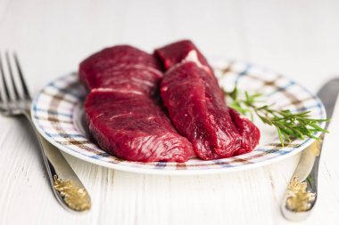 ahşap arka plan üzerinde bir plaka üzerinde taze çiğ Dana biftek