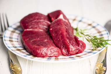 ahşap arka plan üzerinde bir plaka üzerinde taze çiğ Dana biftek