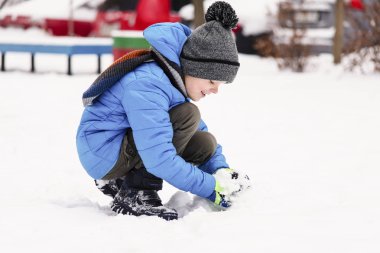 komik çocuk kışın kartopu oynarken