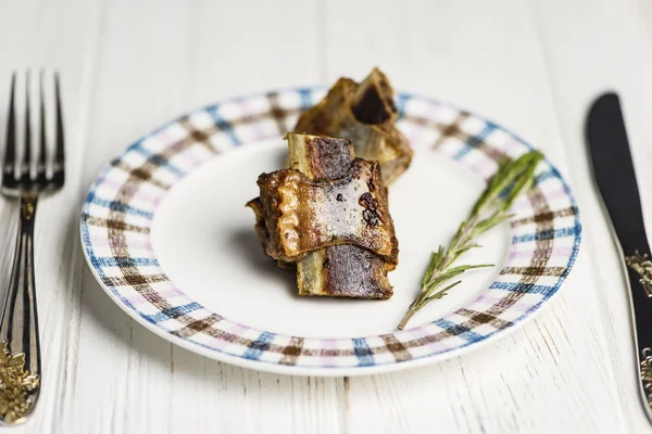 在木制背景的盘子上烤小牛肉的肋骨 — 图库照片