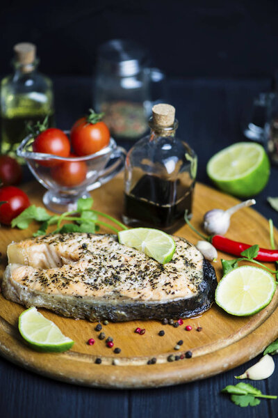 рыбный лосось, запеченный со специями и лимоном на деревянной доске
