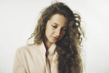 beyaz bir arka plan üzerinde bir ceket uzun kıvırcık saçlı oldukça şık genç kız modeli