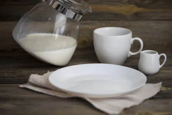 Leche Vierte Una Jarra Vidrio Plato Blanco Vacío Sobre Fondo — Foto de Stock