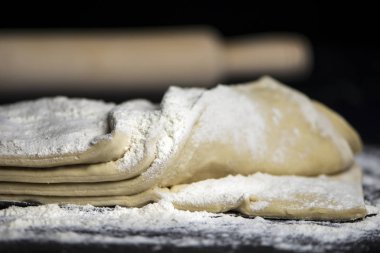 koyu bir arka plan üzerinde un ile ham maya puf böreği