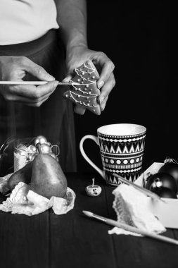 kadın eli karanlık bir arka plan üzerinde kurabiye Noel ağacı süsler