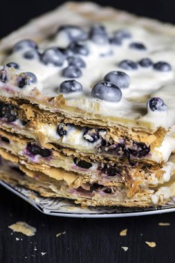 beyaz krema ve berry ile puf böreği pasta, koyu bir arka plan üzerinde yaban mersini