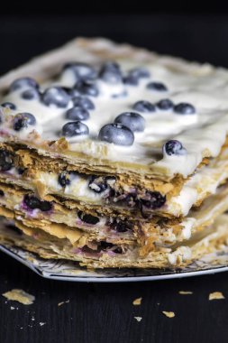 beyaz krema ve berry ile puf böreği pasta, koyu bir arka plan üzerinde yaban mersini