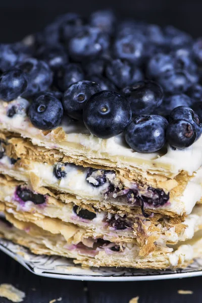 白いクリームとベリー 暗い背景にブルーベリーとパフペーストリーケーキ — ストック写真
