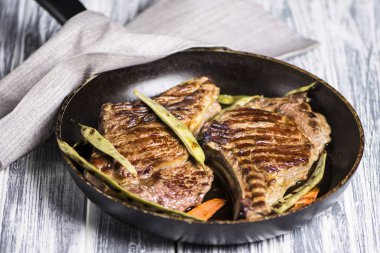 Kuşkonmazlı tavada ızgara biftek ve kemik.