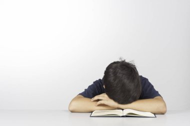 Bambino sudamericano mulatto dorme stanco sul suo libro dopo gli sforzi dello stüdyo
