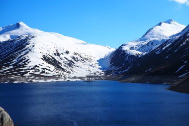 Lago di Santa Maria, Passo del Lucomagno, con vista sulla Val Termine e il Passo dell'Uomo, neve e montagne e natura selvaggia delle Alpi svizzere, Surselva, Valle del Reno, Canton Grigioni, Ticino, Svizzera.