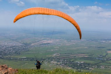 Paraglider paraşütle atlıyor. Yükselen uçuş anı.