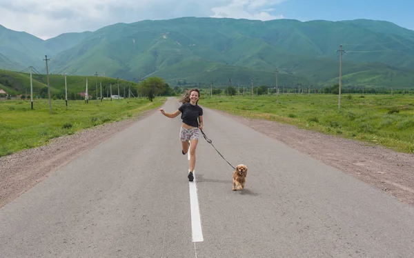 Junge schöne Frau geht mit Hund draußen spazieren — Stockfoto