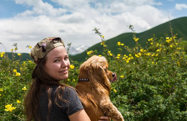 Joven mujer feliz en un prado verde con perro recuperador blanco — Foto de Stock