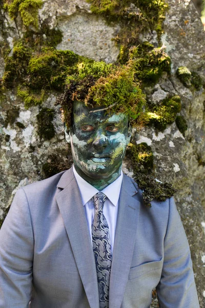 Ofis çalışanı ile açık havada onun yüz ve yeşil yosun kafasında bir makyaj ile bir iş takım elbise. Adam doğa ile birleştirir. — Stok fotoğraf