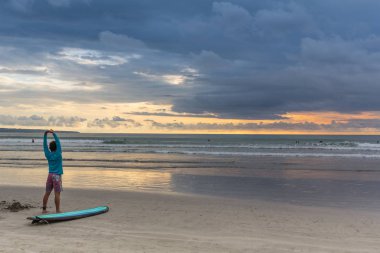 Deniz kıyısında onun elinde duran bir adam ile bir sörf.