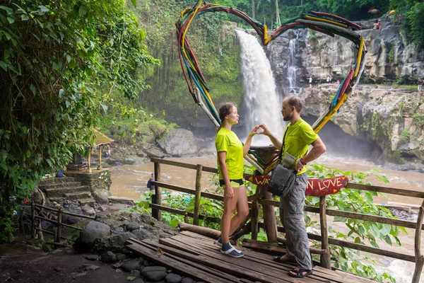 魅力的な若いカップルがジャングルの滝の下でキス — ストック写真