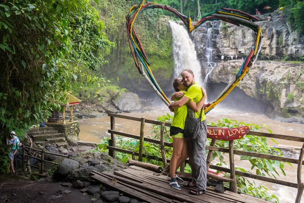 Attraente giovane coppia baciare sotto cascata giungla — Foto Stock