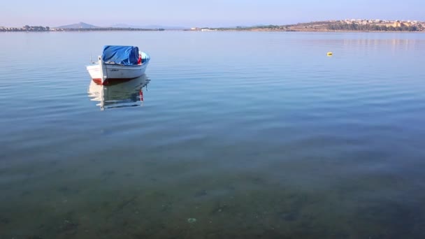 Подошел к белой деревянной лодке с оранжевым буем в воде в бухте Черногории — стоковое видео