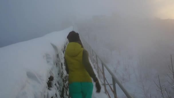 Deux amies marchant sur le pont de corde skywalk dans les montagnes entourées de brouillard dense. Tourisme en Europe — Video