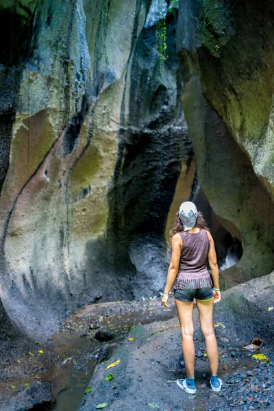 Aktive Wanderin durch malerischen dichten Nebelwald mit Felsschlucht und Baum mit Rucksack auf Laufstrecke. — Stockfoto