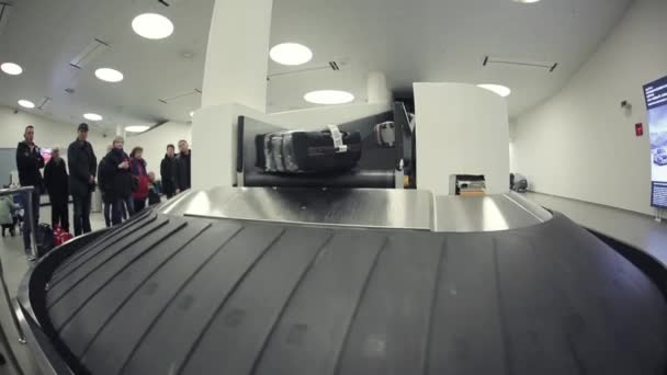 Moscow, Russia - July 25, 2017: People at the airport are waiting for their luggage near the baggage escalator — Stock Video