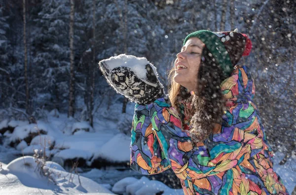 Рождественский портрет девушки на открытом воздухе. Зимняя женщина, выдувающая снег в парке — стоковое фото