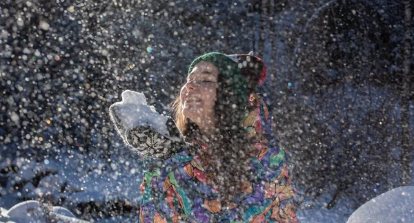 Beauty Winter Girl Blowing Snow (em inglês) no Frosty Winter Park. Ao ar livre. Flocos de neve voadores. Dia ensolarado. De trás. Joyful Beauty jovem mulher se divertindo no parque de inverno . — Fotografia de Stock