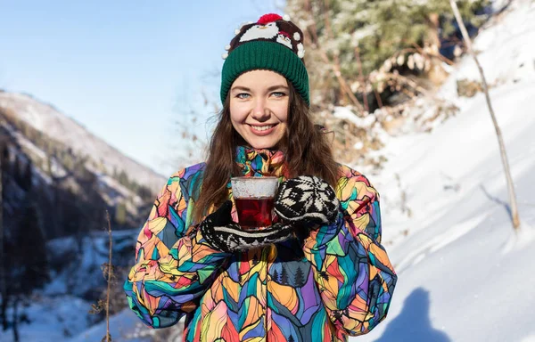 Kız kar düşüyor hoşlanır. Örme şekil genç kadın ormanda kar yağışı sırasında çay içiyor. Tonda fotoğraf — Stok fotoğraf