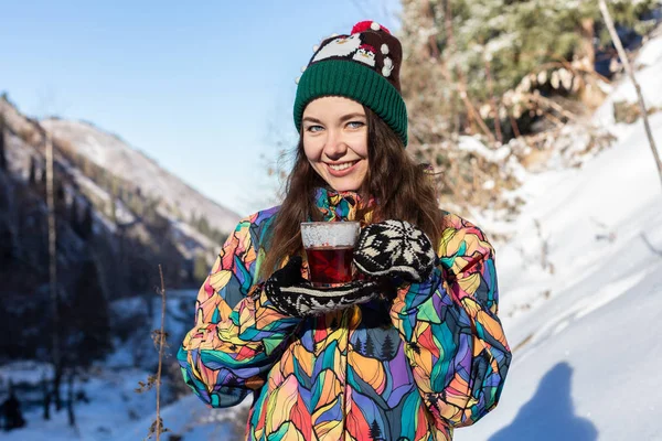 Kız kar düşüyor hoşlanır. Örme şekil genç kadın ormanda kar yağışı sırasında çay içiyor. Tonda fotoğraf — Stok fotoğraf