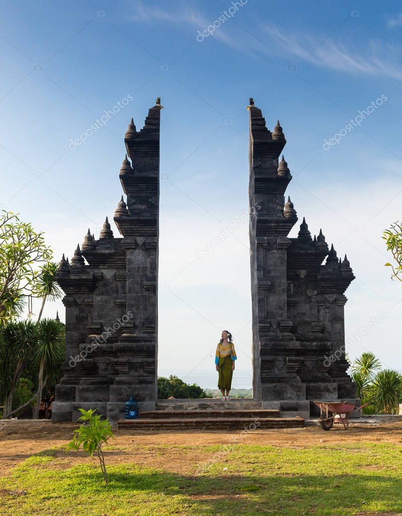 Girl is standing in the gate of Pura Lempuyang temple on Bali island, Indonesia
