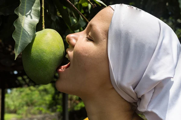 女孩吃绿色芒果水果直接从树上 — 图库照片
