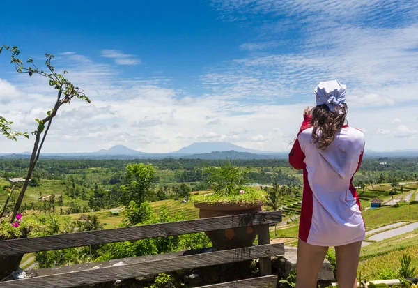 Familienurlaub. junge Frau steht am Rand einer überhängenden Brücke auf einer hohen Klippe. glückliches Mädchen mit Blick auf atemberaubende tropische Dschungel-Ansicht. tukad melangit ist beliebtes Reiseziel in bali. — Stockfoto