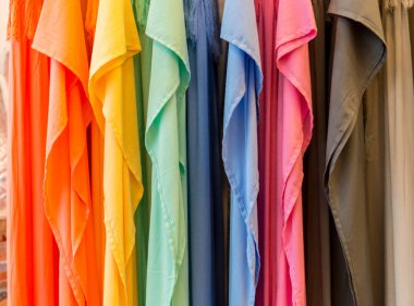 Moda giyim giyim raf - parlak renkli dolabın üzerinde. Gökkuşağı renk seçimi trendy kadın giyim askıları mağaza dolap veya bahar temizliği kavramı üzerinde Close-up. Yaz ev gardırop.