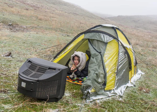 Kız niteliğine bir çadır içinde yatıyor ve eski bir Tv izliyor — Stok fotoğraf