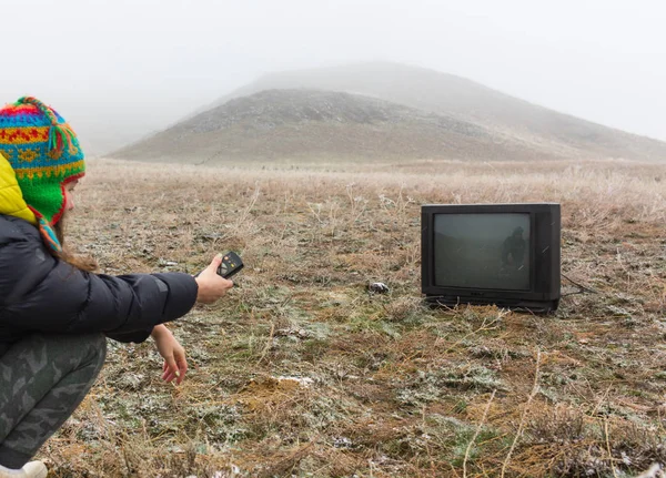 Fille sur la nature couché sur le sol et regarder une vieille télévision — Photo