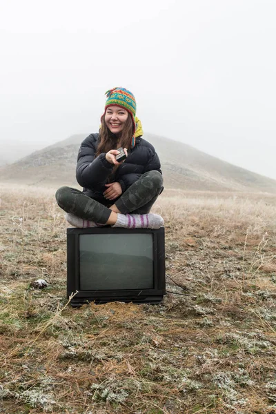 Fille dans la steppe assis sur la télévision . — Photo