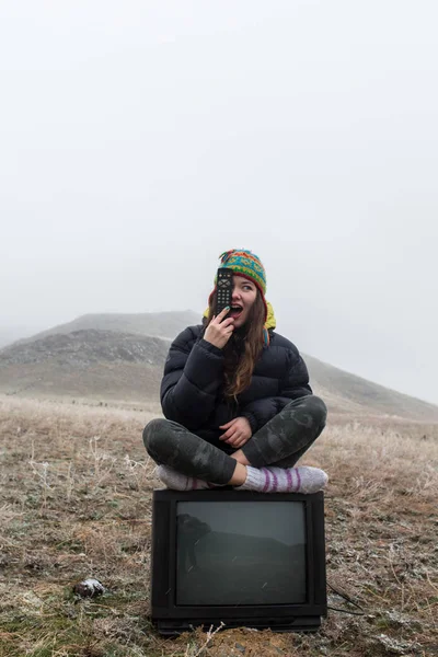 Fille dans la steppe assis sur la télévision . — Photo