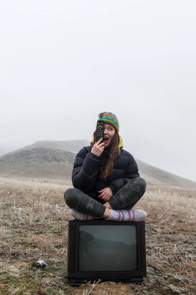 Mädchen in der Steppe sitzt auf dem Fernseher. — Stockfoto