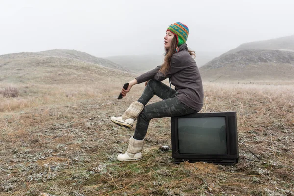 Girl in the steppe sitting on the TV. — Stock Photo, Image