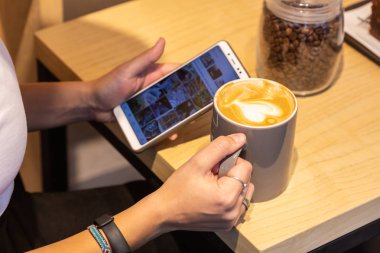 Sıcak süveterin içinde bir akıllı telefon kullanan kadın. Yakın çekim