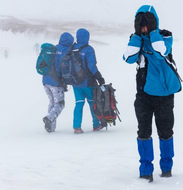 Almaty Kazakistan - 03 Şubat 2019: Tanımlanamayan insanlar yürümek-den geçerek bir kar fırtınası sırasında belgili tanımlık kış dağlarda Alpinerais yarışma sırasında. 02 Şubat 2019, Kayak Merkezi Çimbulak.