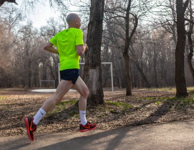 Almaty Kazakistan - 16 Mart 2019: Kimliği belirsiz Baum sonra 16 Mart adında bir Grove Almatı şehir bahar maraton sırasında bir koru ile çalışır.
