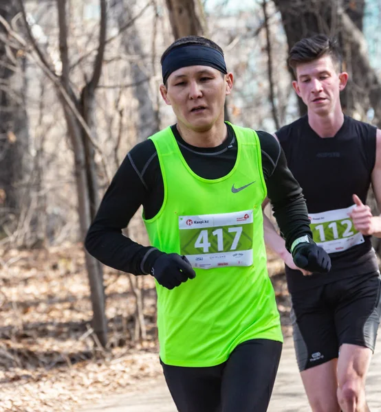 Ałma Ata, Kazachstan - 16 marca 2019: portret przystojny dojrzałe niezidentyfikowany mężczyzna, który prowadzi przez las maratonu wiosna w mieście Almaty, Grove, nazwany na cześć Baum marca — Zdjęcie stockowe