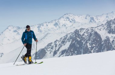 Dağcı backcountry kayak Ski sırt çantası içinde ile karlı bir sırt boyunca yürüyüş. Arka plan mavi gökyüzü ve parlak güneş ve Zebru, Ortler Güney Tirol, İtalya. Macera kış aşırı spor.
